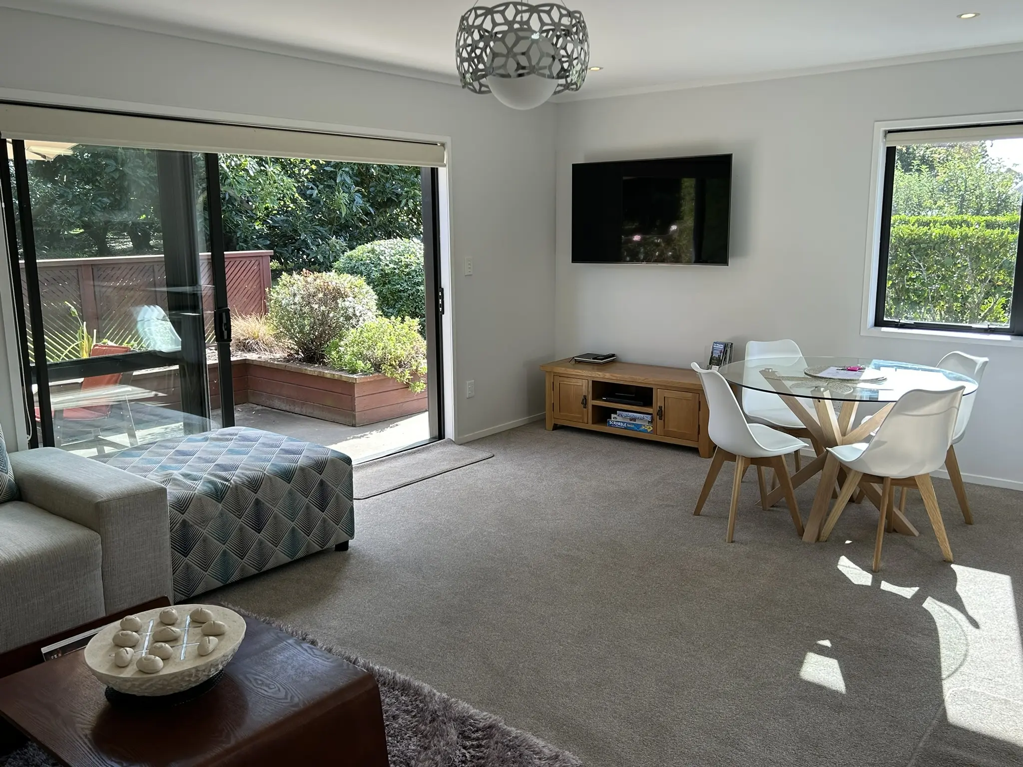 Spacious lounge with large flat-screen TV and sliding doors to the deck at Baybell Lodge