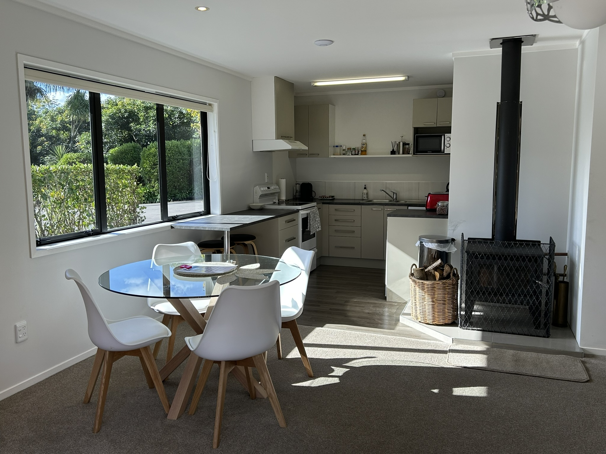 Fully equipped kitchen with woodburner fireplace and orchard views at Baybell Lodge