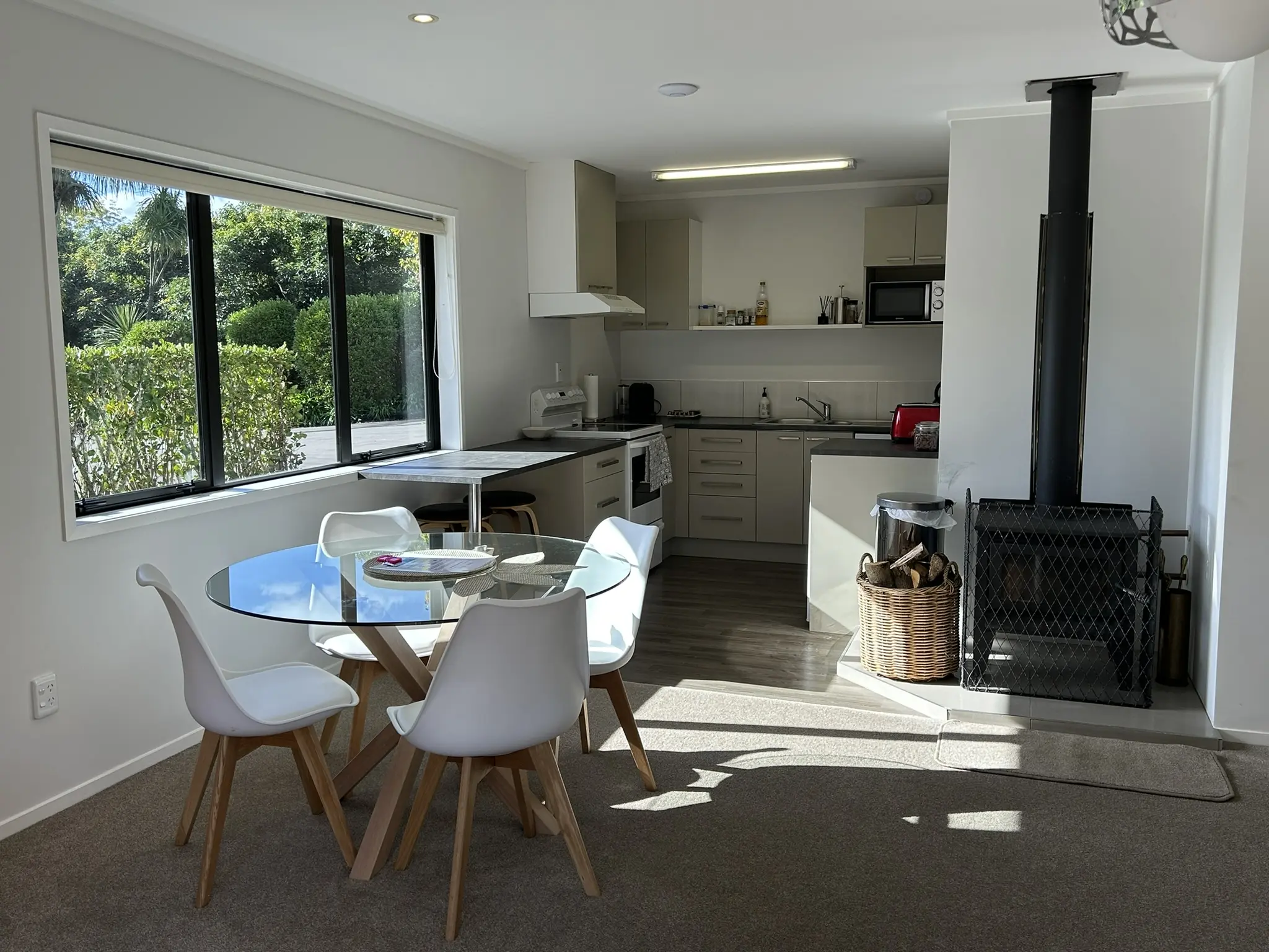 Fully equipped kitchen with woodburner fireplace and orchard views at Baybell Lodge