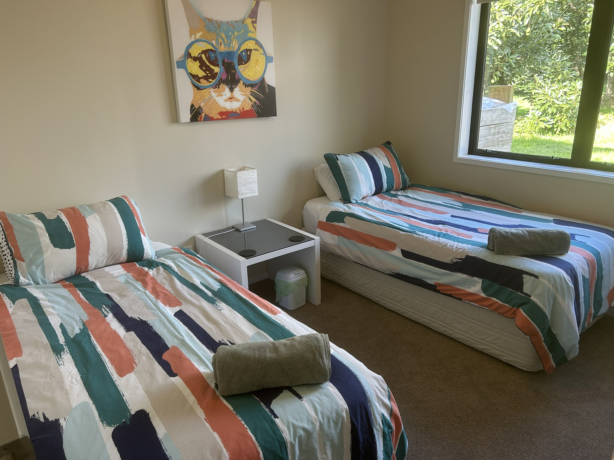 Twin bedroom with two single beds and orchard views at Baybell Lodge