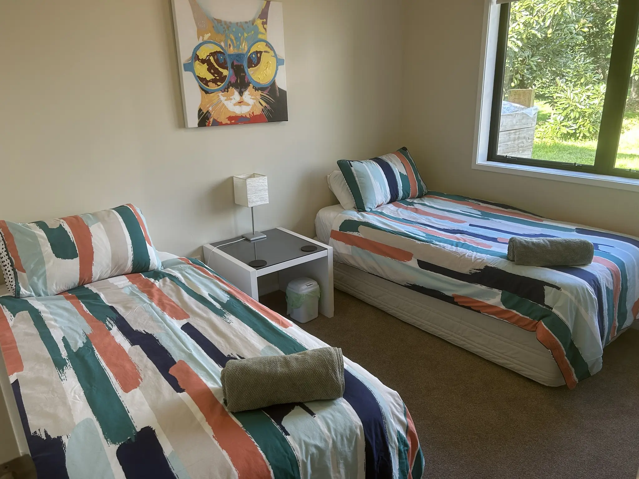 Twin bedroom with two single beds and orchard views at Baybell Lodge